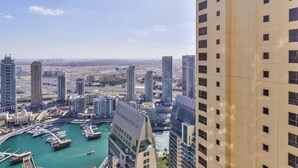 A high-rise building with a marina in the foreground and other high-rise buildings in the background. - Luxury 3BR JBR · Shams · Free 5* Beach Resorts Access! (Dubai)