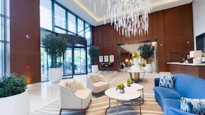 A modern lobby with a reception desk, seating area, and large windows. - Address Dubai Opera Residences I 2BR Deluxe Suite (Dubai)