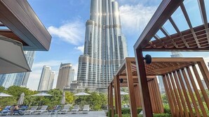 A rooftop pool area with a view of the Burj Khalifa. - Address Dubai Opera Residences I 2BR Deluxe Suite (Dubai)
