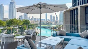 A rooftop lounge with a city view, a pool, and modern outdoor furniture. - Address Dubai Opera Residences I 2BR Deluxe Suite (Dubai)