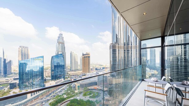 Habitación de hotel en un edificio alto con vistas panorámicas de la ciudad, ventanas amplias y un diseño de interiores moderno.