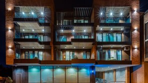 A multi-story building with balconies, large windows, and exterior lighting. - Studio Balcony Suite with Kitchen (T'bilisi)