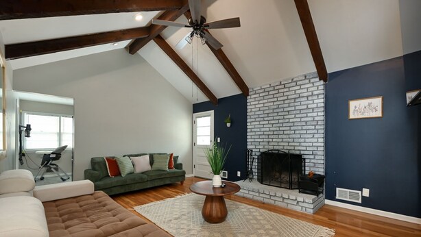 A living room with a fireplace, a green sofa, and a brown sectional sofa. - Relaxing Space for Families & Friends — Sleeps 10 + Pet-Friendly (Grandview)