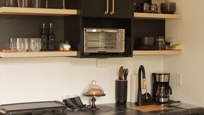 Una cucina moderna con mobili neri, forno integrato e macchina da caffè.