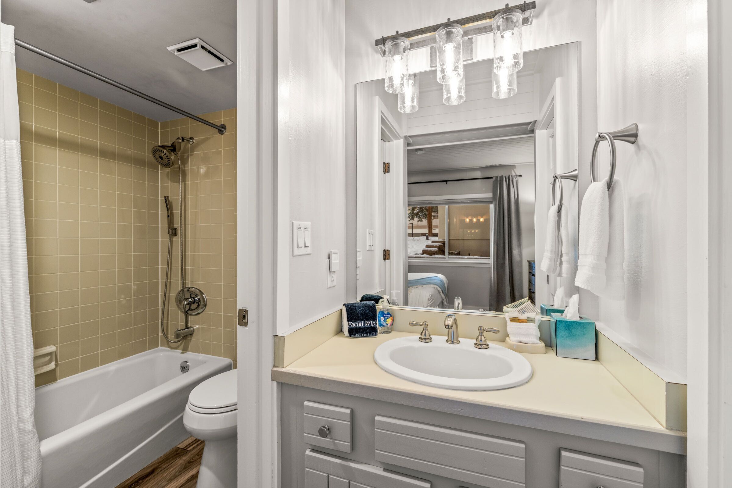 A bathroom with a bathtub, toilet, sink, and mirror.