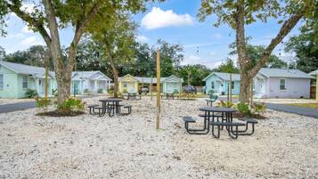 Een camping met picknicktafels en vakantiehuisjes.