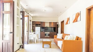 A modern living room with a sofa, coffee table, and kitchen in the background. - Casa de mabel (Santo Domingo)