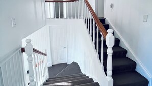 A staircase with white railings and dark carpeted steps. - Holiday Home In Red Hill Papakura Auckland With Beautiful Views (Papakura)