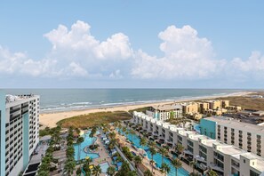 Ein Resort mit mehreren Schwimmbecken, einem Strand und Meerblick.