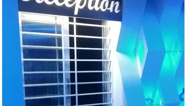 A reception area with a sign that reads "Reception" above a window with blinds.