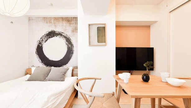 Een moderne slaapkamer met een bed, nachtkastje en een aan de muur bevestigde televisie.