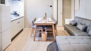 A compact living space with a kitchenette, dining area, and a sofa. - Triphome Asakusa Alpha 2 Bedrooms (Taito City)