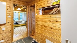 Un intérieur en bois avec un canapé, une porte donnant sur un balcon et un radiateur fixé au mur.