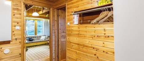 A wooden interior with a sofa, a door leading to a balcony, and a wall-mounted heater.