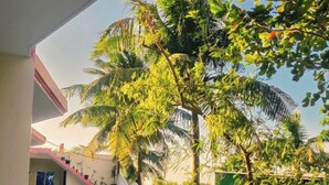 A covered walkway with a tiled floor, bordered by a white railing, leading to a building with a blue roof. - Heaven beach Resort Saint Martin (Saint Martin's Island)