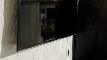 Un téléviseur à écran plat fixé sur un mur blanc à texture.
