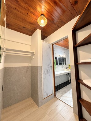 A bathroom with a wooden ceiling, a marble wall, and a wooden shelf. - Hotel Villa Napoli (Santa Ana)