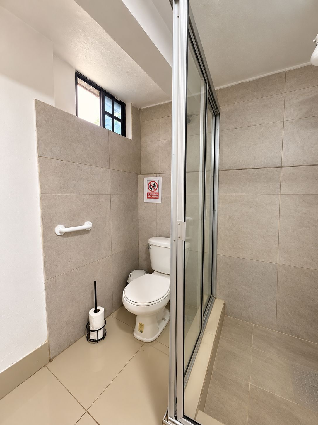 Une salle de bain moderne équipée de toilettes, d’un bidet et d’une douche à parois de verre.