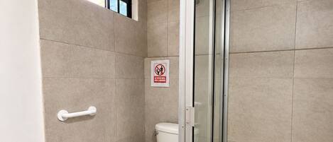 Une salle de bain moderne équipée de toilettes, d’un bidet et d’une douche à parois de verre.
