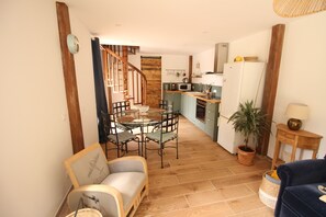 A cozy interior with a dining area, kitchen, and a staircase. - Les Séquoias Vacation Rental with Pool and Sauna Near Paris & Giverny (Cierrey)