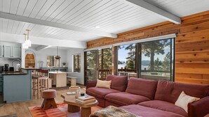 Un intérieur moderne avec un mur d’accent en bois, un canapé rouge et un coin cuisine.