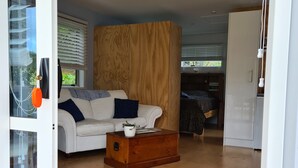 Ein modernes Wohnzimmer mit einem weißen Sofa, einem Holztisch und einer großen Holzwand.