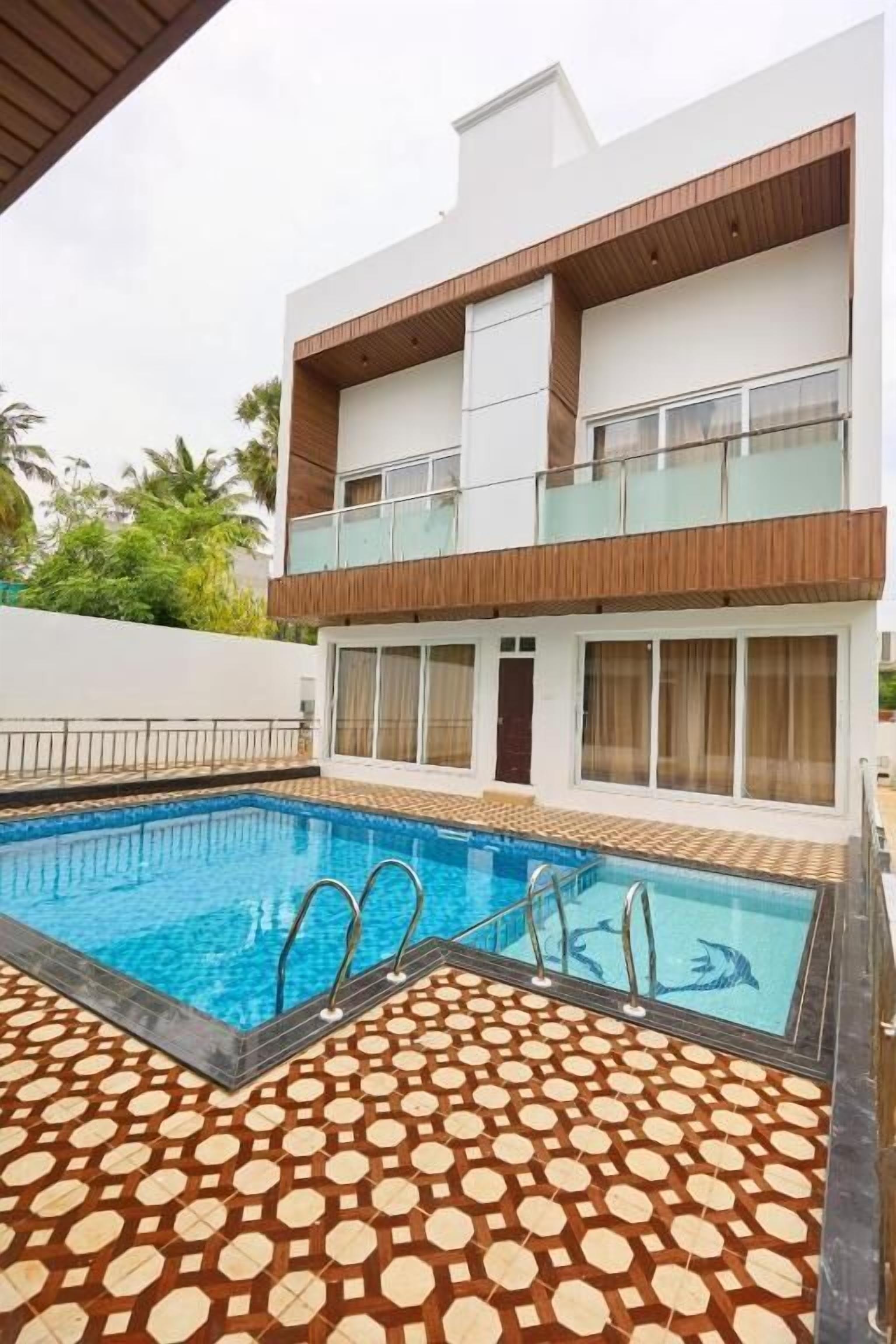 A modern two-story building with a swimming pool in the foreground.