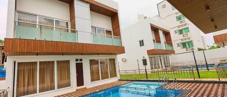 Un edificio moderno con piscina, balcones y suelo estampado.