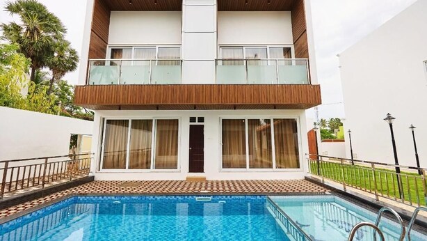 Un bâtiment à deux étages avec une piscine devant.