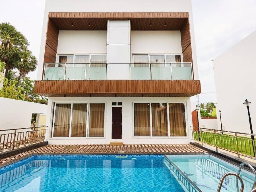 A two-story building with a swimming pool in front.