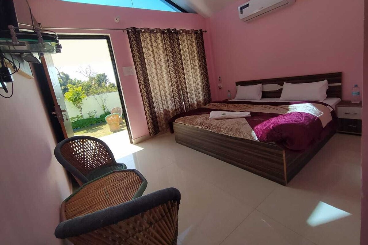 Ein Schlafzimmer mit einem Bett, einem Sessel, einem Fenster und einer Klimaanlage.