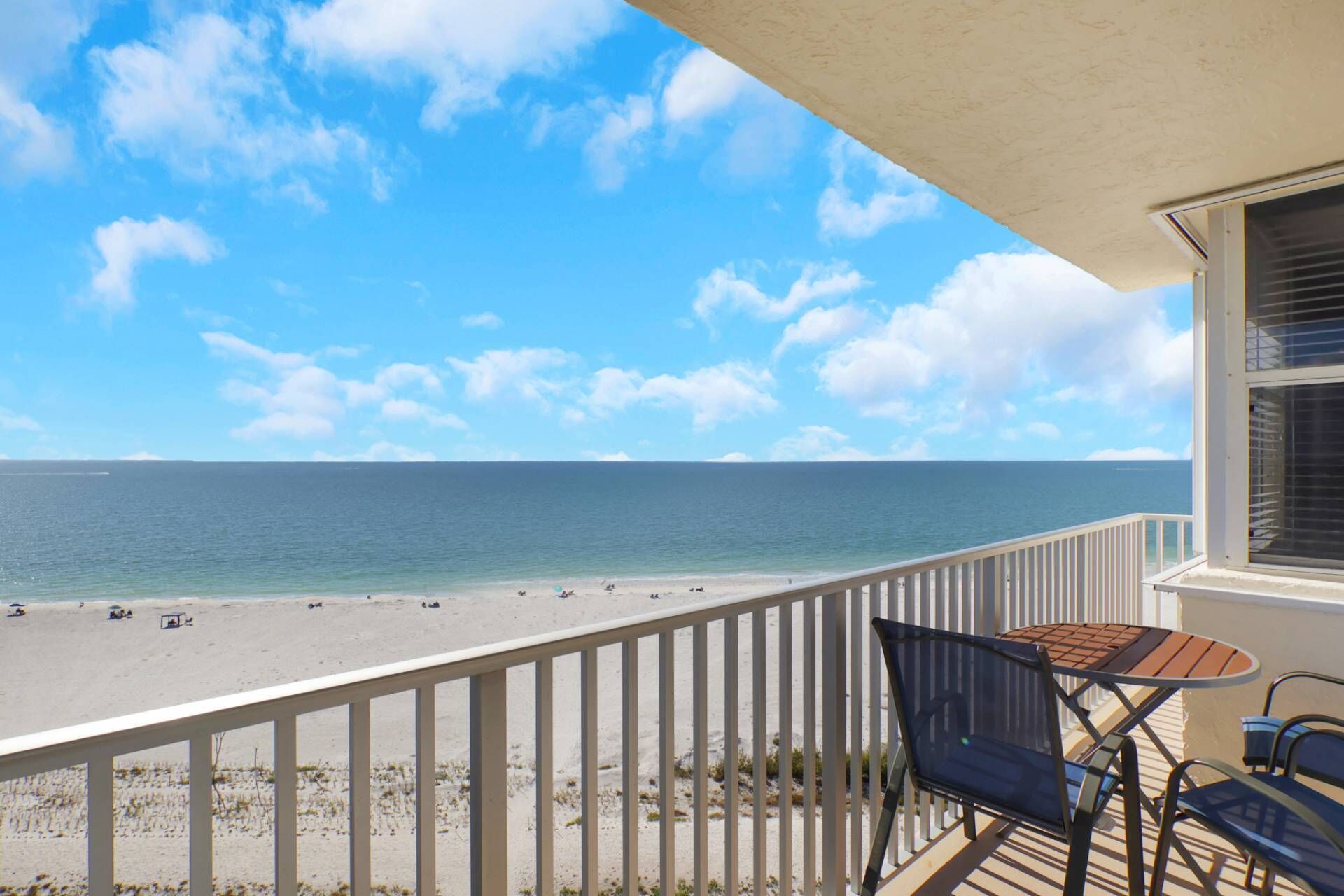 Un balcon avec vue sur une plage et l’océan.