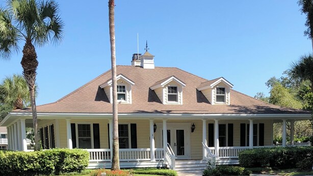 A two-story house with a porch, a chimney, and a well-maintained lawn. - Family friendly 3-bedroom townhome with large sunroom  in St. Simons Island (St. Simons Island)