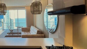 Een moderne keuken met een gasfornuis, een groot raam en uitzicht op de stad.