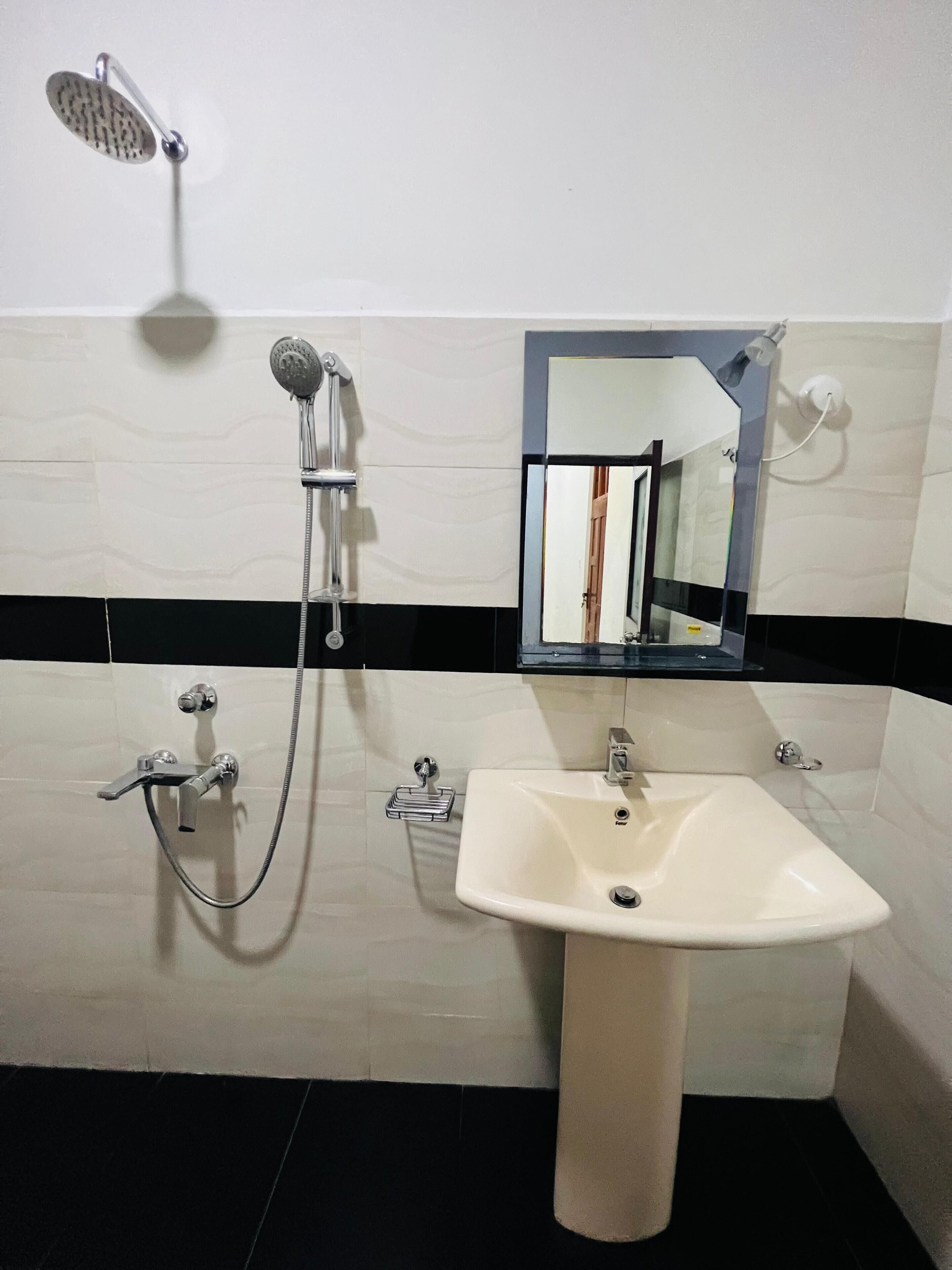 A bathroom with a shower, a sink, and a mirror.