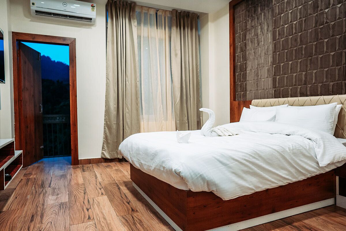 A bedroom with a wooden bed, a window with curtains, and an air conditioning unit.