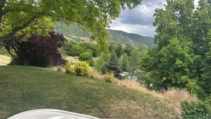 A hot tub in a lush garden with a view of a valley and hills. - East Farmington Hideaway (Farmington)