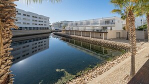 Ett modernt hotell med en pool med kristallklart vatten, en gång av sten och palmer.