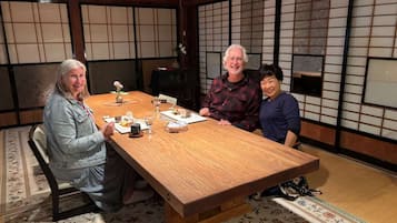 Een traditionele Japanse kamer met tatami vloerbedekking, een lage houten tafel en shoji schermen.