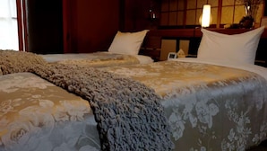 Una cama doble con una colcha estampada y un plaid texturizado.