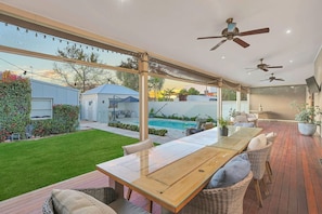A spacious patio with a pool, outdoor furniture, and ceiling fans. - The Retreat on Chaffey (Mildura)