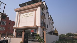 Un edificio a più piani con un cartello che riporta la scritta "Parmanand Bhawan".