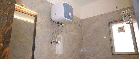 A bathroom with a marble wall, a hand dryer, a towel rack, and a shower.