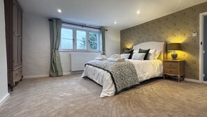 A bedroom with a bed, bedside table, lamp, window, and curtains. - Hill House - UK49727 (King&rsquo;s Lynn)
