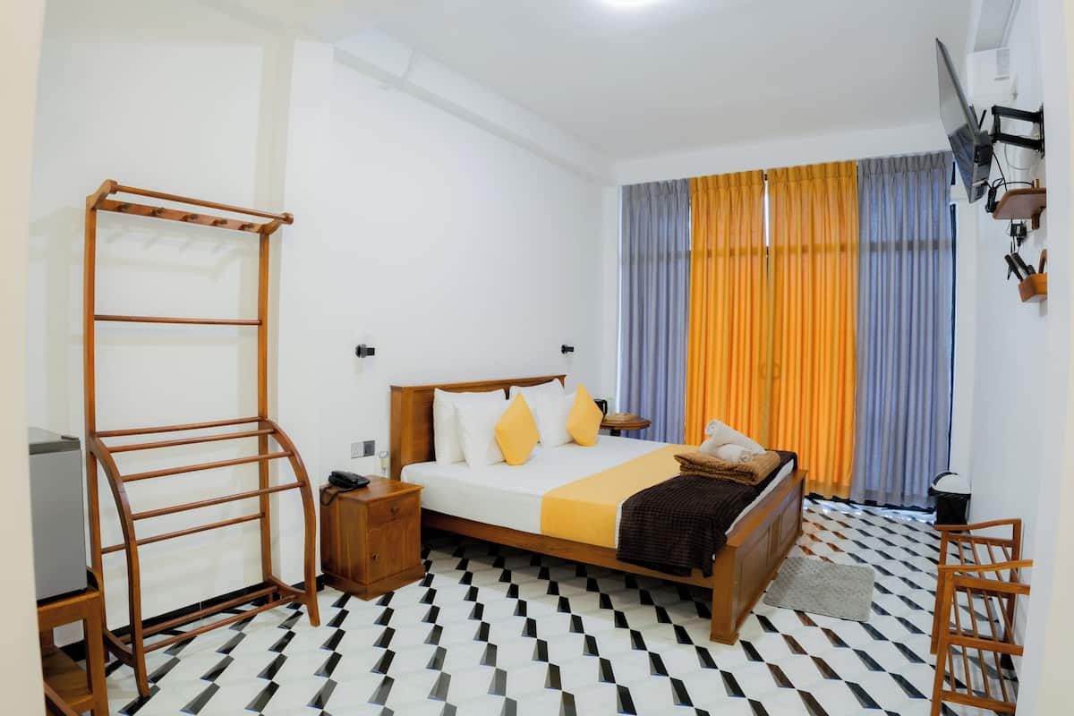 A bedroom with a bed, a wooden ladder, a nightstand, a desk, and a chair.