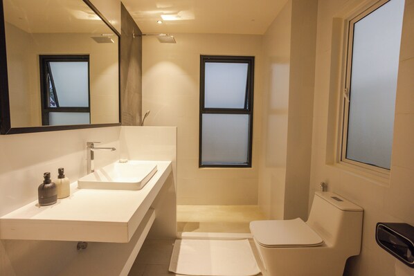 A modern bathroom with a white sink, mirror, and toilet. There are two windows providing natural light. - Aqua Luna Dhangethi (Dhangethi)
