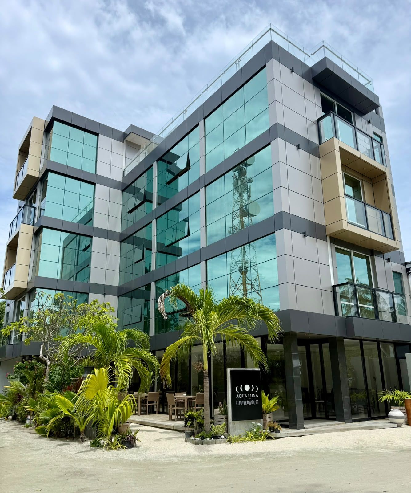 A modern building with multiple floors, large glass windows, and a sign reading 'AQUA LUNA'.