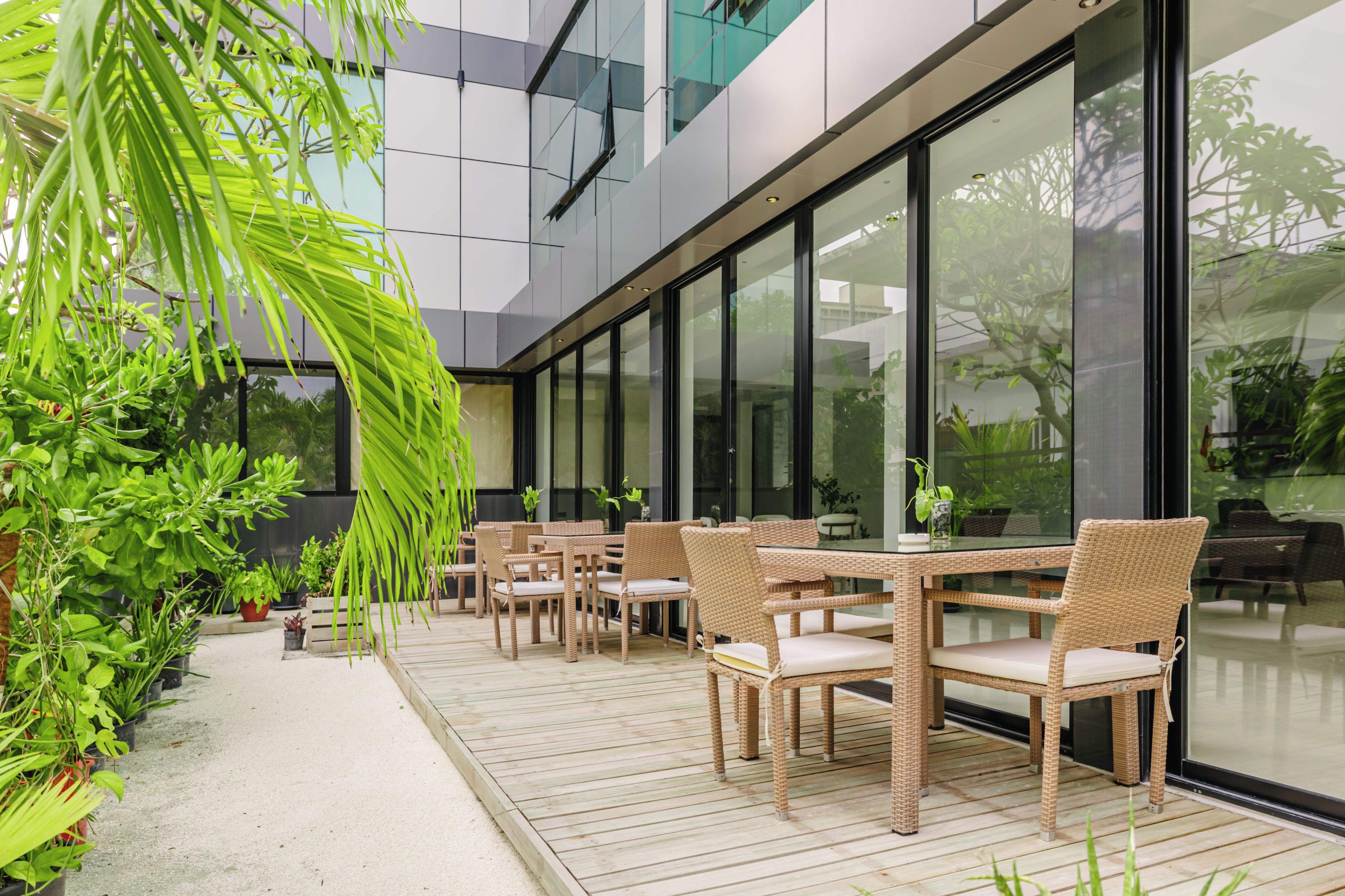 An outdoor seating area with wicker furniture and potted plants.
