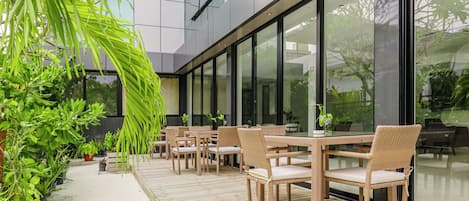 An outdoor seating area with wicker furniture and potted plants.