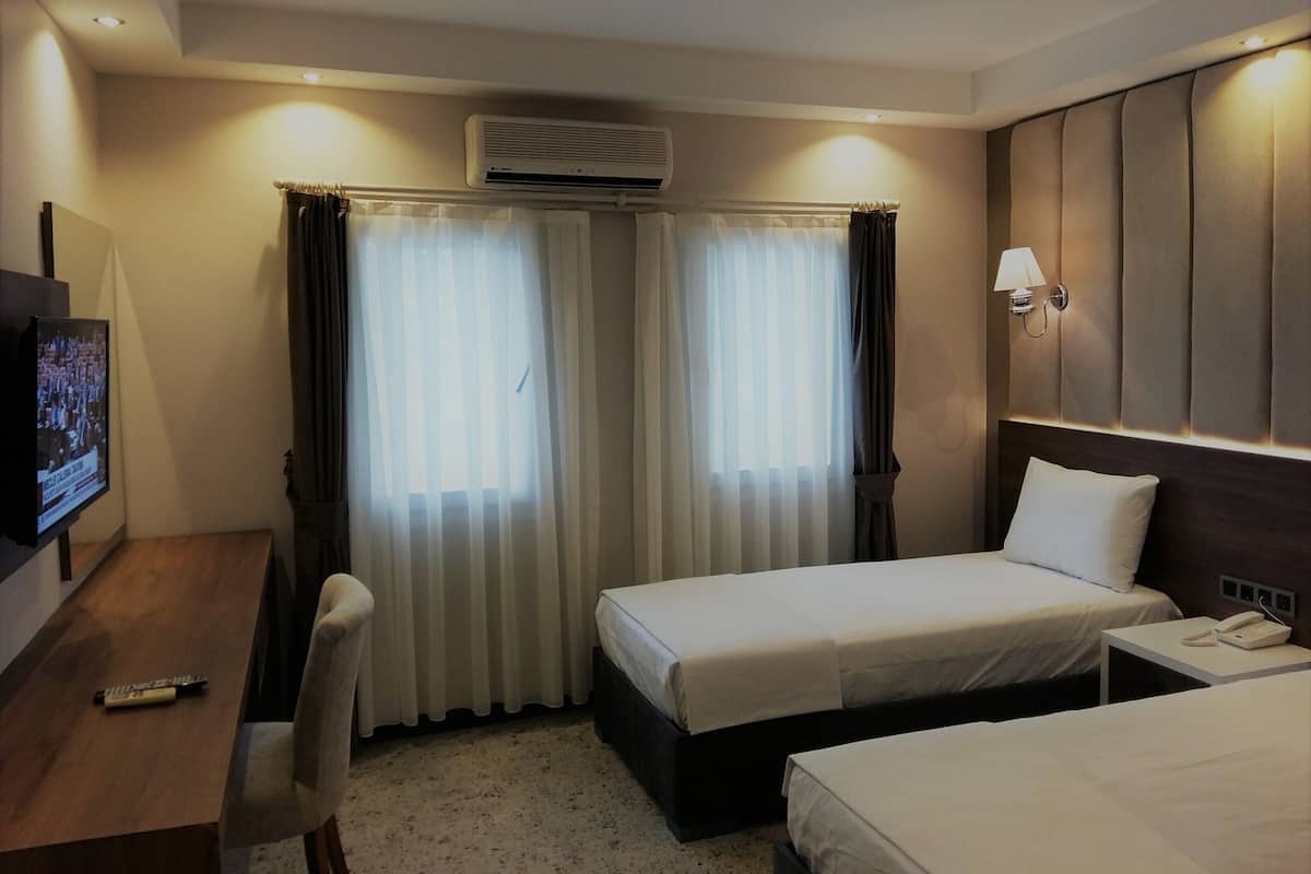 Habitación triple estándar, vista al jardín | Caja de seguridad en la habitación y cortinas blackout